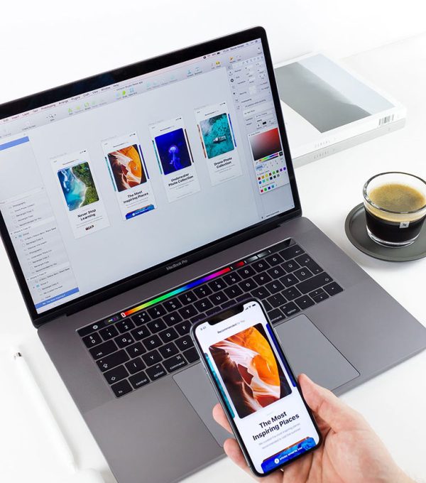 laptop con diseños de aplicación móvil o pagina web con una tasa de café y una caja en el fondo