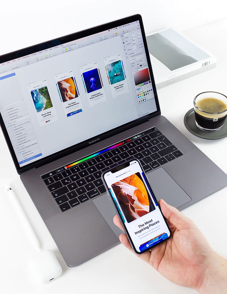 laptop con diseños de aplicación móvil o pagina web con una tasa de café y una caja en el fondo