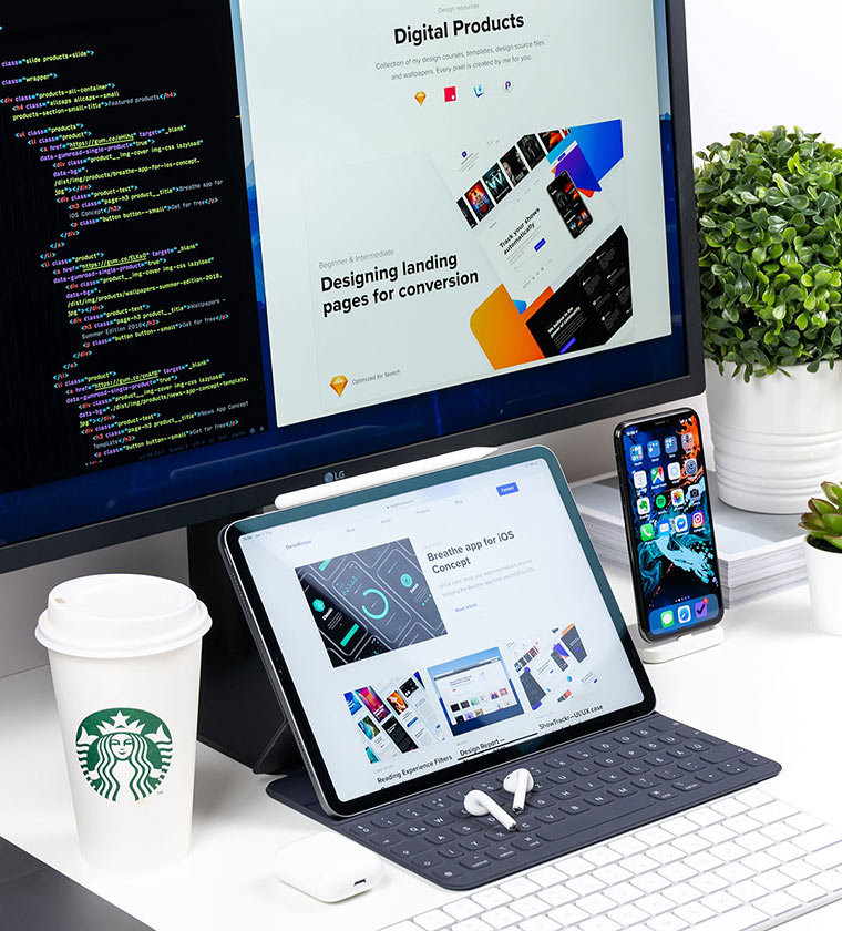 Setup con vaso de café, un iPad con funda y teclado y un iPhone sobre una mesa con unos airPods.