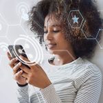 Mujer interactuado con su dispositivo móvil mientras podemos ver algunos de los servicios que este tiene disponibles